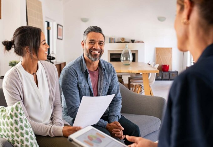 People discussing 15-year vs. 30-year fixed mortgage options with loan officer.