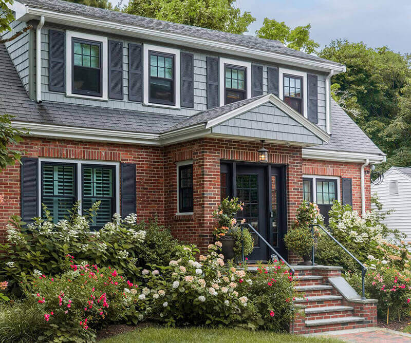 Exterior brick house with flowers and bushes