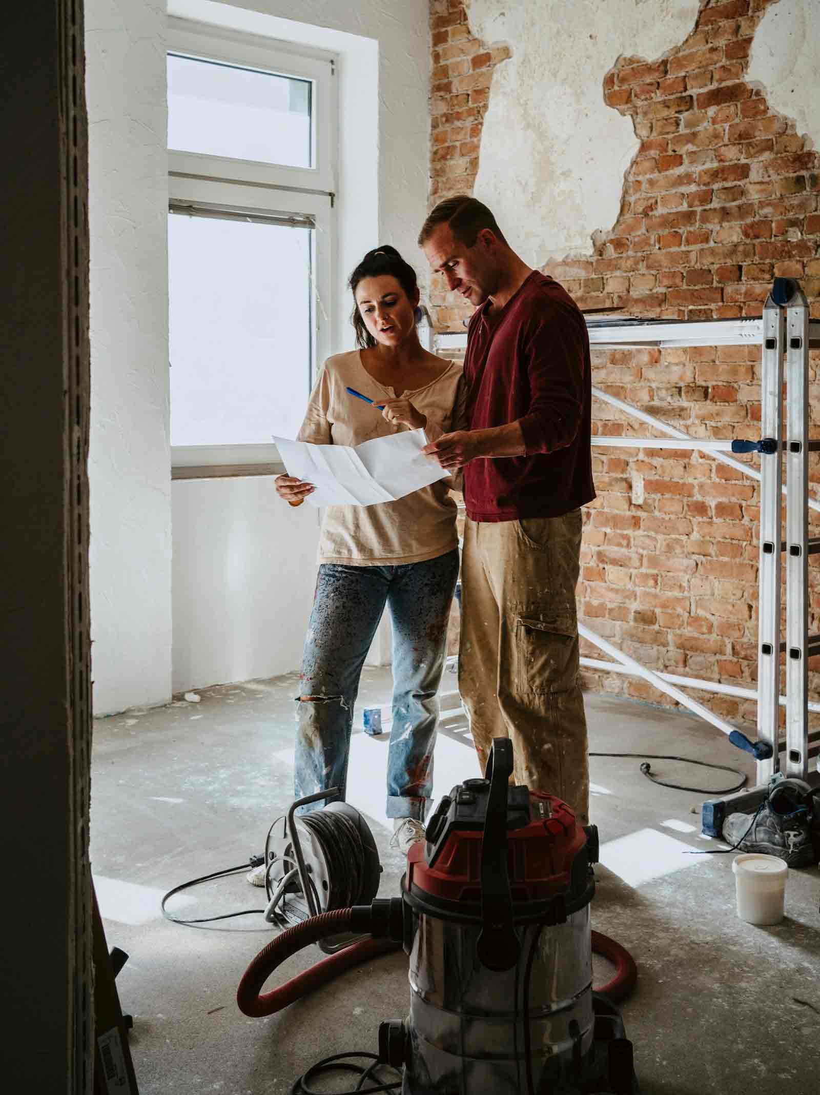 Contractor and homeowner review renovation plans inside home being improved using home equity.
