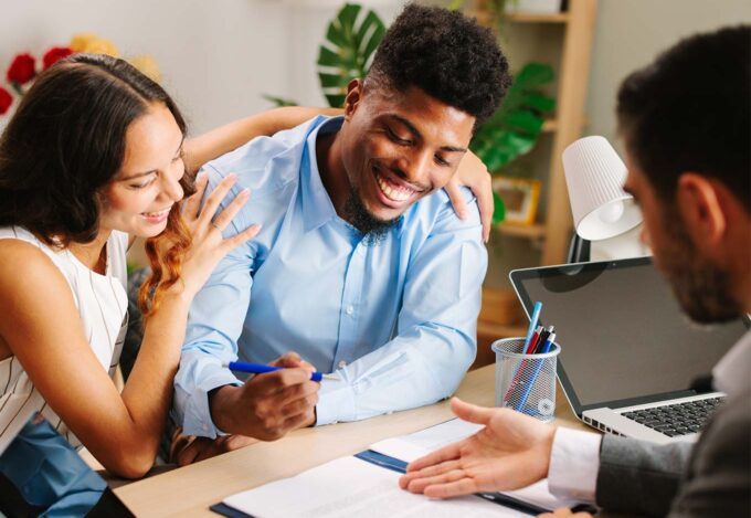 Couple sits down with mortgage loan officer to calculate how much it would cost for them to refinance.