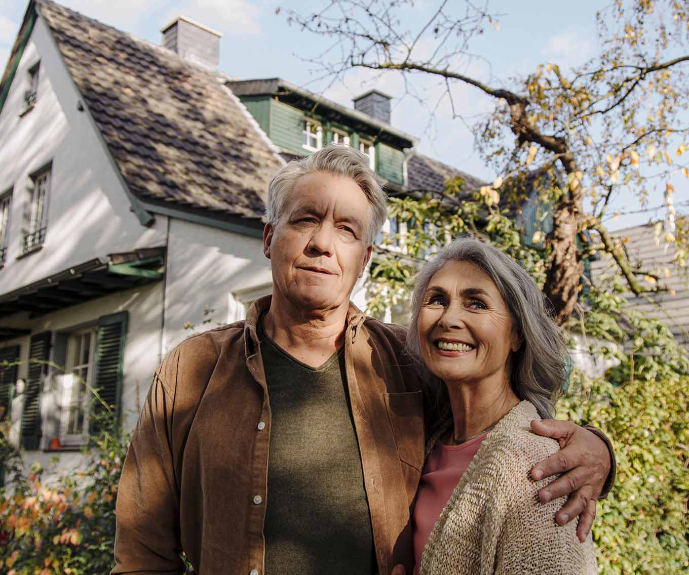 Couple in front of suburban home considers their cash-out refinance home equity.
