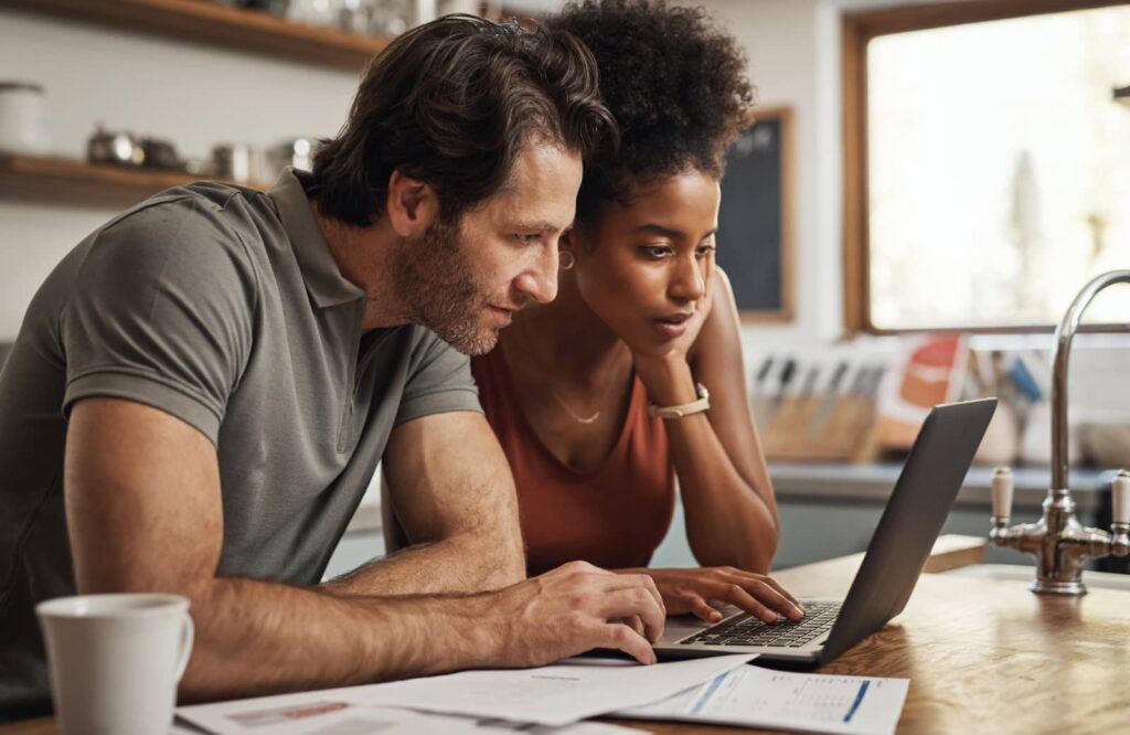Couple sitting together at table considers fixed-rate mortgage paperwork.