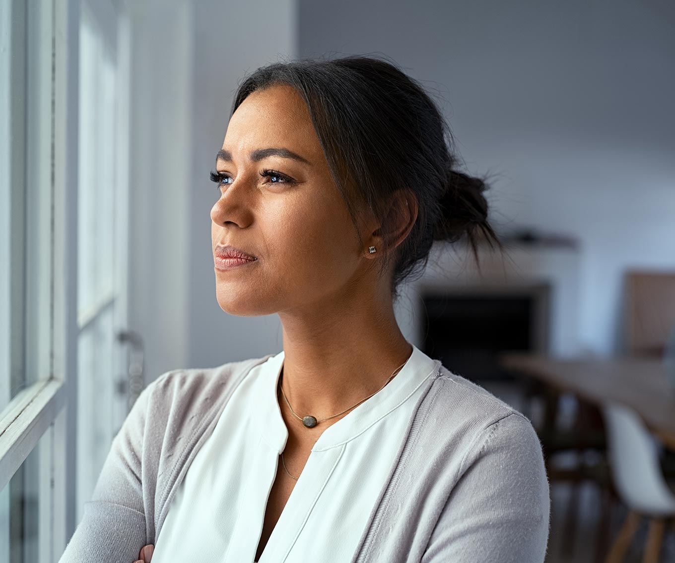Woman looks out window and considers the mortgage pre-approval on her house.