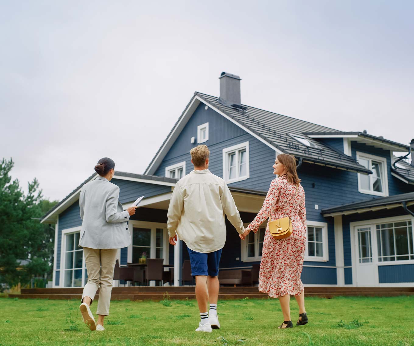 Couple tours outside of house for sale with their real estate agent.