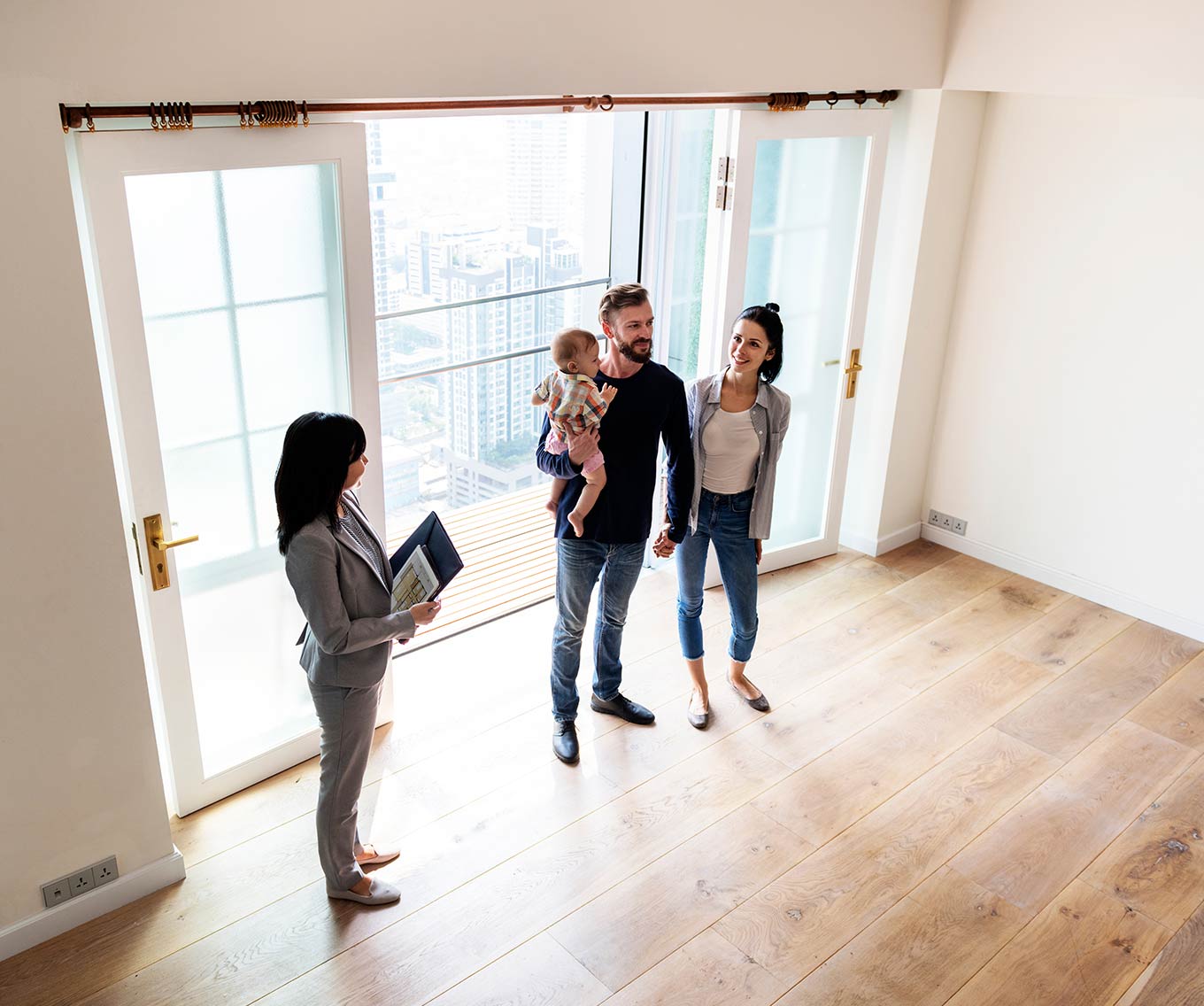 Couple and child tour home for sale during open house with real estate agent.