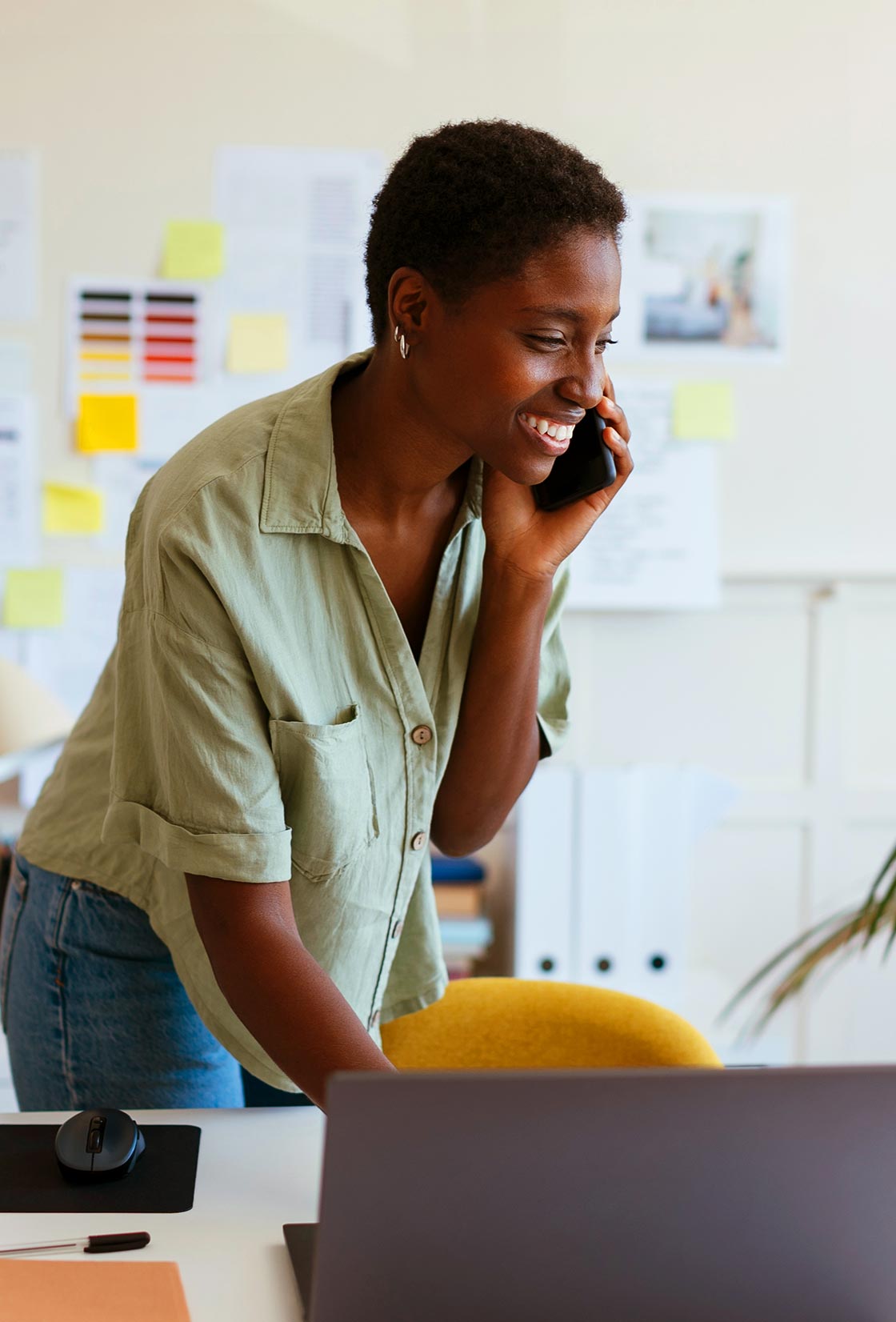 A woman in her home office is excited to learn about down payment assistance options.