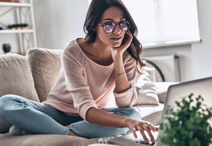 Woman researching when you can refinance a mortgage on a computer.