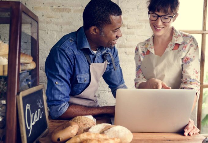 Self-employed bakery owner researches 1099 mortgage on laptop