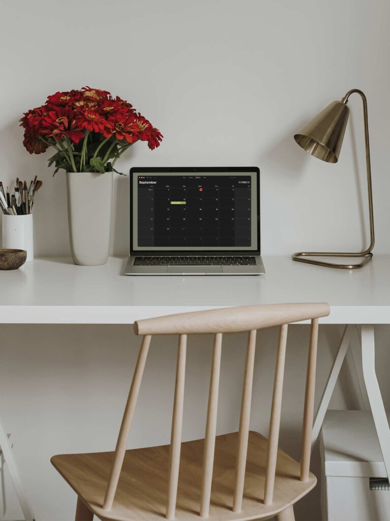 Laptop on desk in home office shows closing day on calendar.
