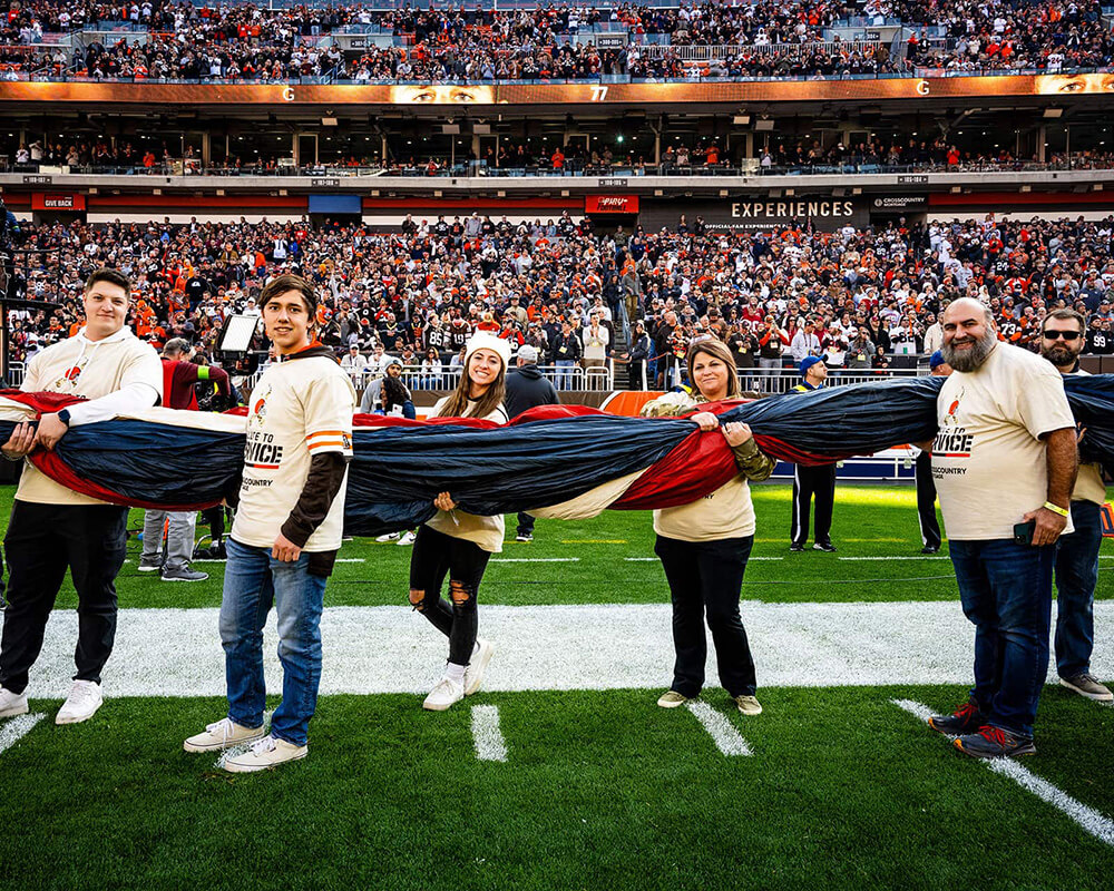 CCM Veterans holding the American Flag at the Salute to Service game.