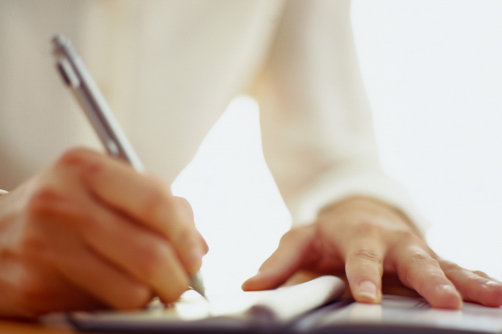 Someone writing a check for their mortgage payment