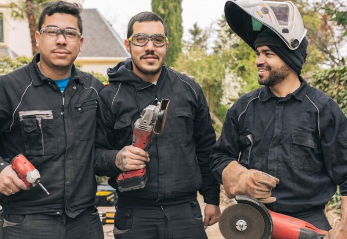 Three construction workers working outside on a house.