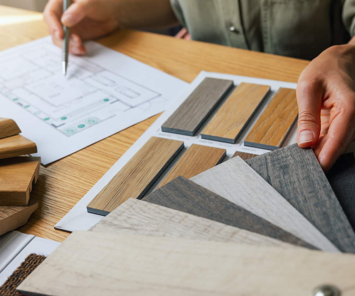 Person looking at home renovation plans and flooring options.