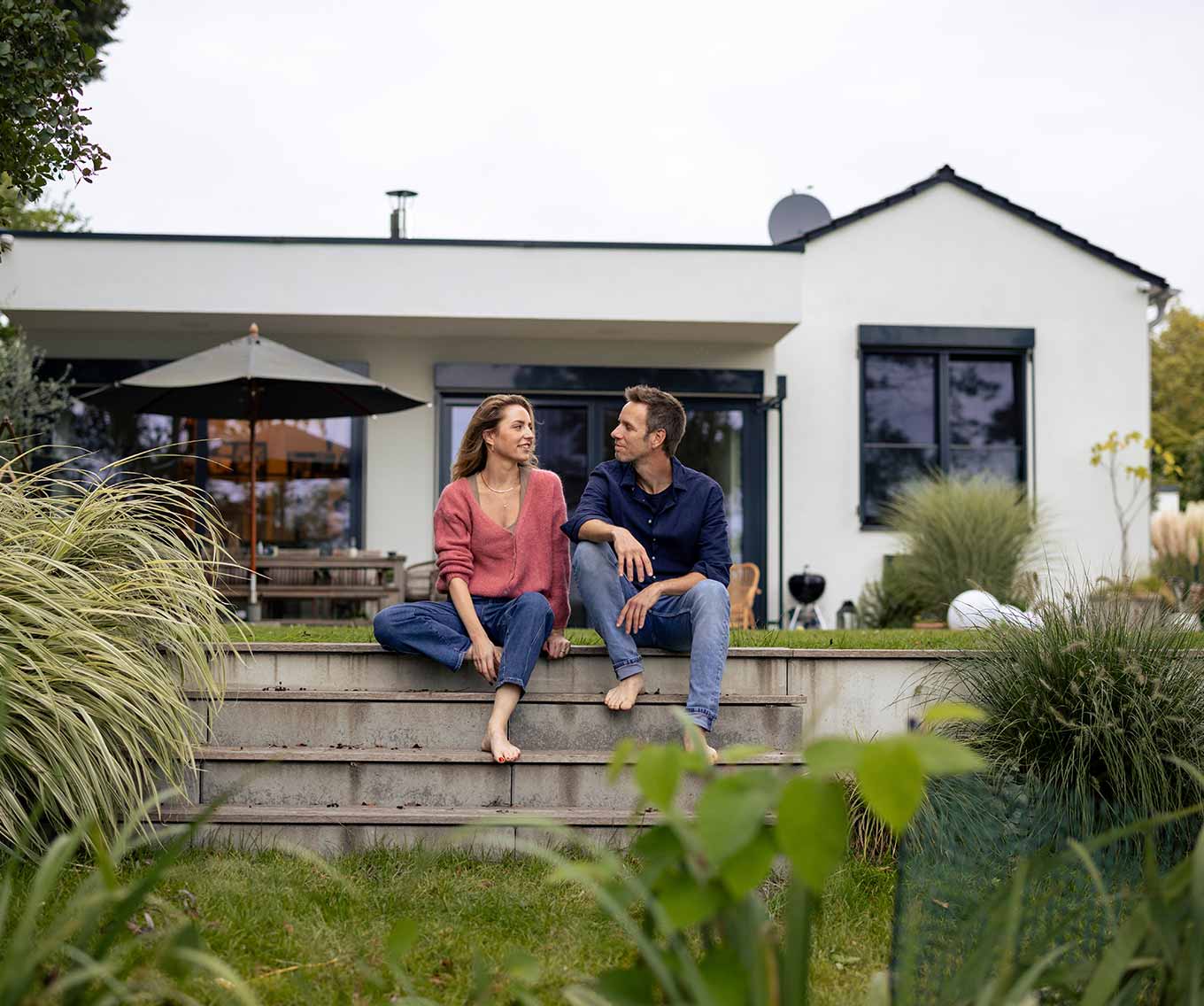A couple sitting on their porch discussing when mortgage rates will go down & their mortgage refinance options.