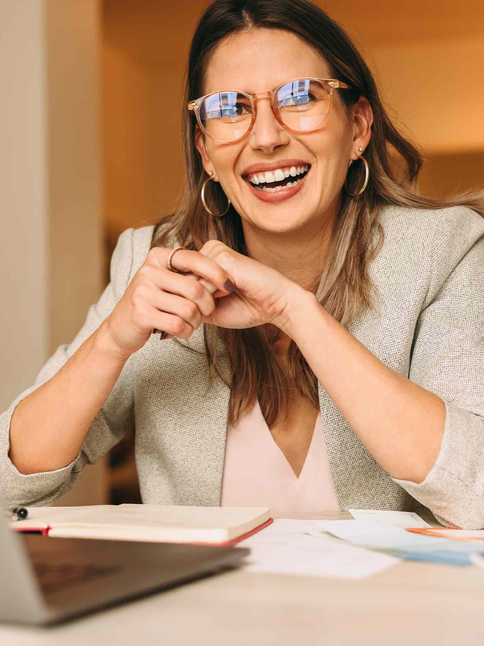 Woman sits at desk in front of computer researching refinance mortgage loans.